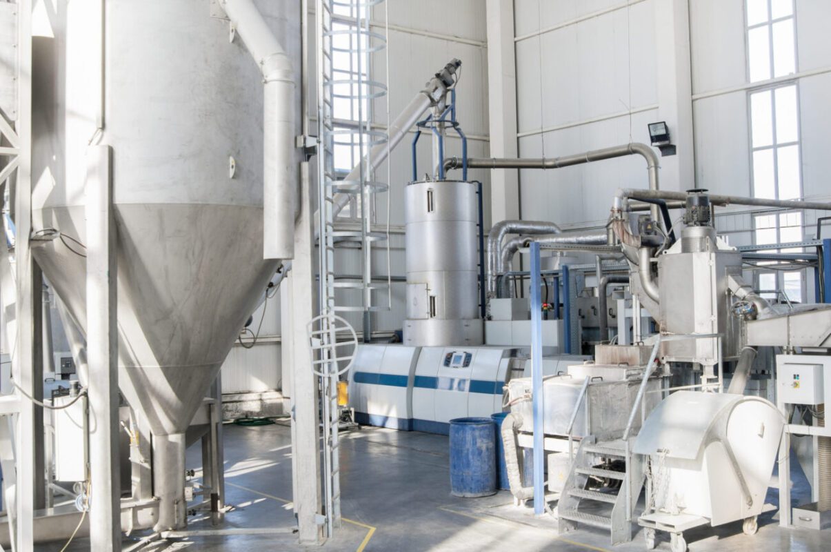 777955 Equiper | diario-economia.com Industrial processing plant with a tall conical silo, stainless pipes, and control panels visible.