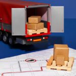 Toy delivery truck with open back loaded with wooden blocks next to a map with red route lines.