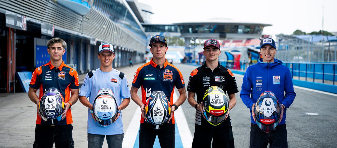 Pont Grup Pilotos - IP | diario-economia.com Five race car drivers stand in a pit lane, each holding a helmet and wearing team uniforms with sponsor logos.
