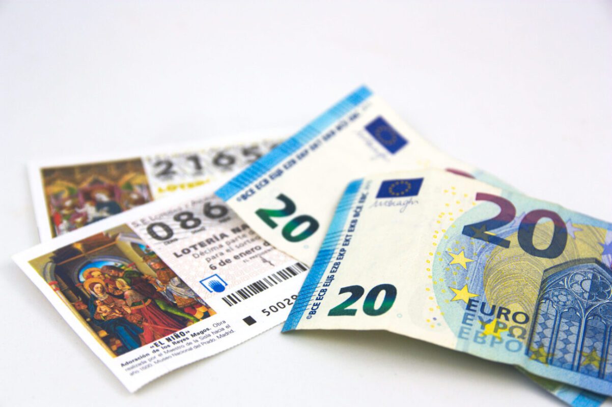 Several colorful Euro banknotes fanned on a white surface, featuring a prominent 20-euro note.