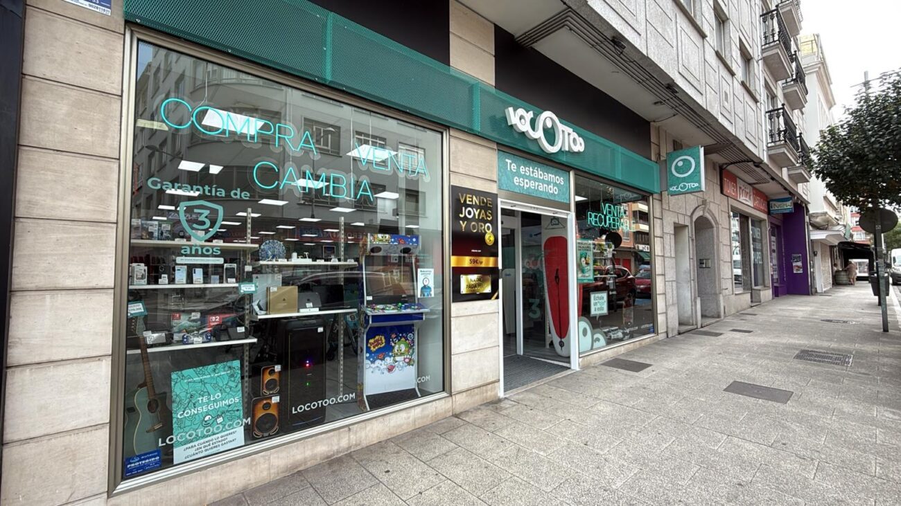 Locotoo - IP | diario-economia.com Storefront with teal signage advertising 'Compra Vende Cambia'; large glass window displays merchandise inside the shop on a city sidewalk.