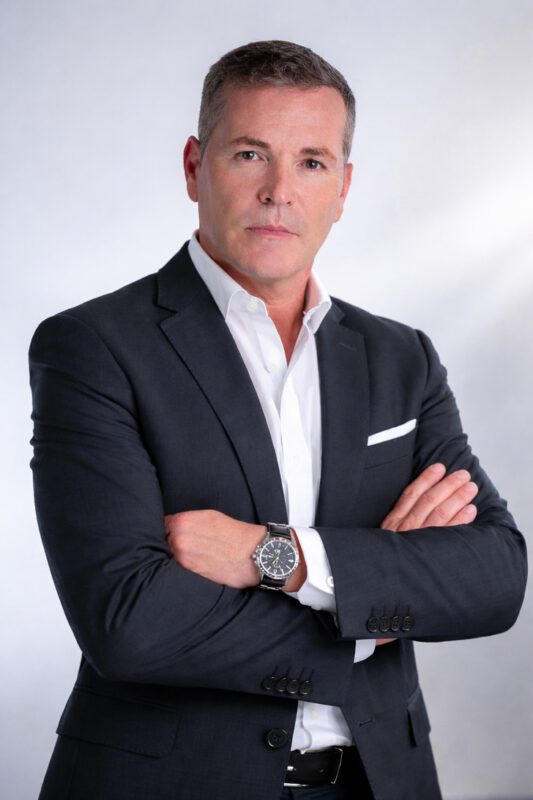 Pegasus Capital - IP | diario-economia.com Professional man in a navy suit with white shirt, arms crossed, neutral expression, business portrait.